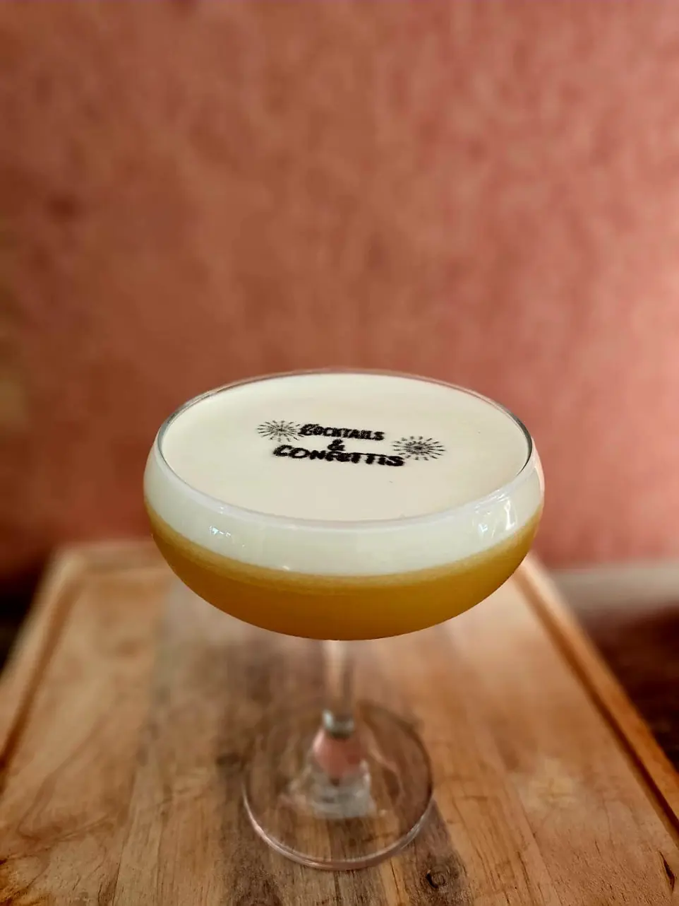détail d'un cocktail versé dans une coupe de champagne sur une tablé décoré